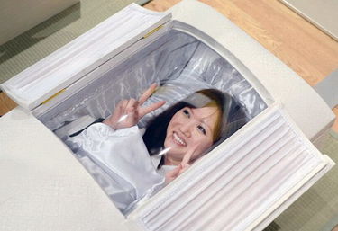 日本举办丧葬用品宣传活动 参加者体验躺棺材